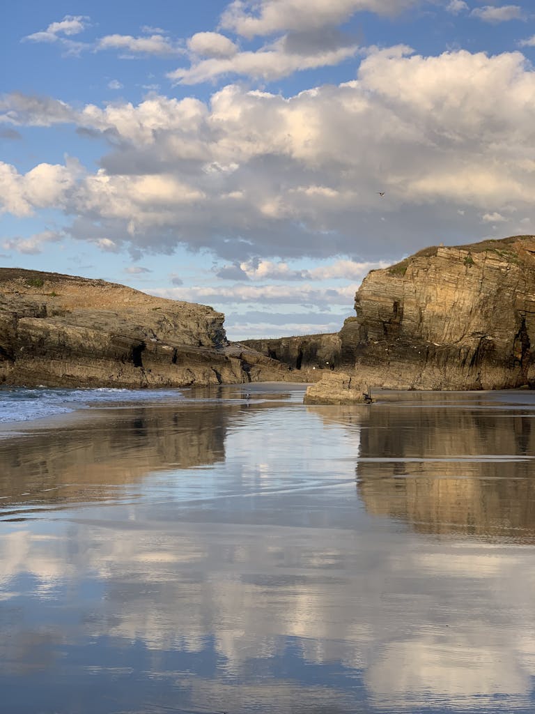 Captivating view of majestic cliffs and reflections on the water at Ribadeo, Spain.