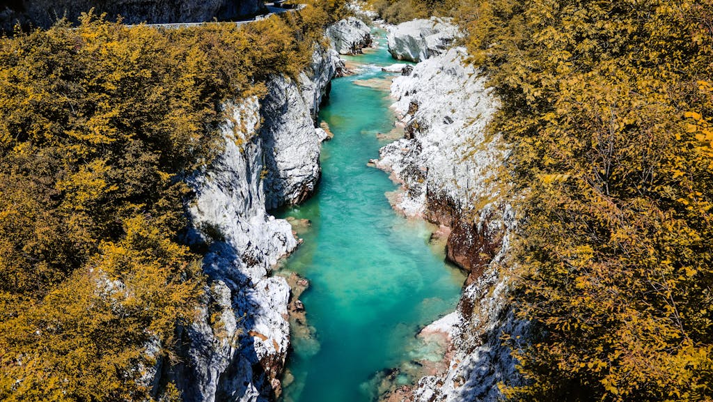 Discover the stunning turquoise waters of the Soca River flowing through the scenic landscape of Slovenia.