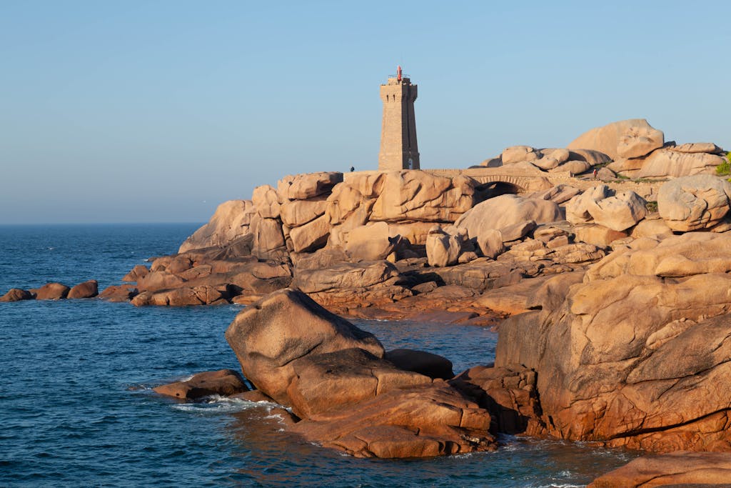 Iconic Phare de Men Ruz Lighthouse on rocky coast in Perros-Guirec, Brittany, France.