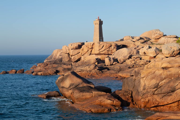 Iconic Phare de Men Ruz Lighthouse on rocky coast in Perros-Guirec, Brittany, France.