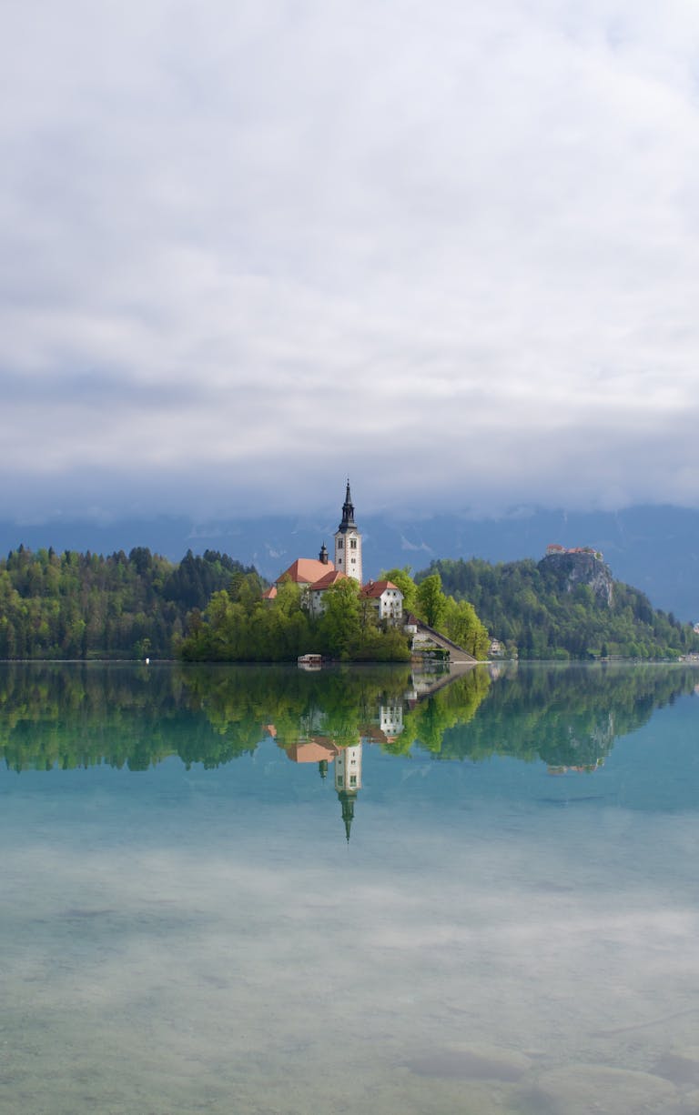 Serene reflection of Bled Island and church on Lake Bled, Slovenia.