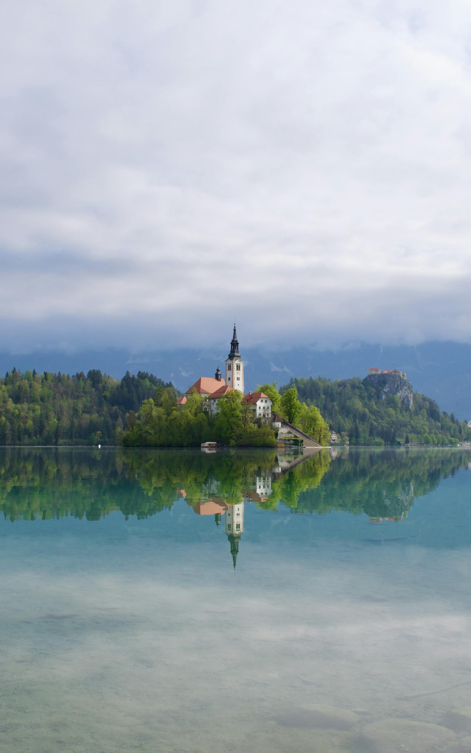 Serene reflection of Bled Island and church on Lake Bled, Slovenia.